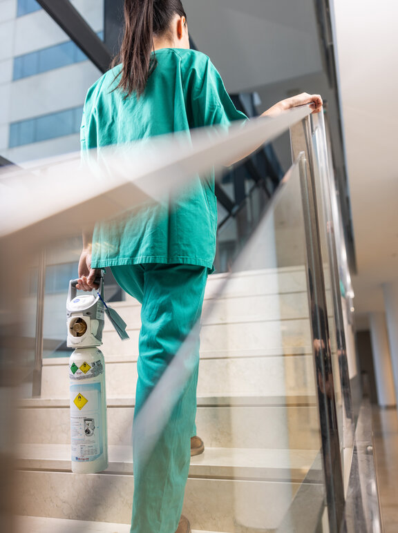 Professionnelle de santé transportant une bouteille d'oxygène à l'hôpital